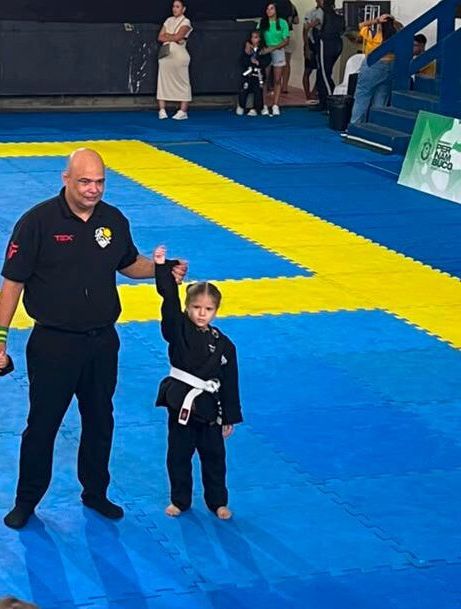 Lorena Veloso com o braço erguido pelo árbitro após a vitória no Festival Pernambucano Kids